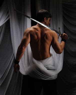 seksi adam bir kılıç tutuyor