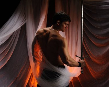 seksi adam bir kılıç tutuyor