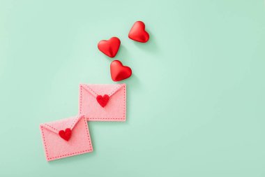 Renkli arkaplanda Sevgililer Günü için kırmızı kalpli zarflar vardı.