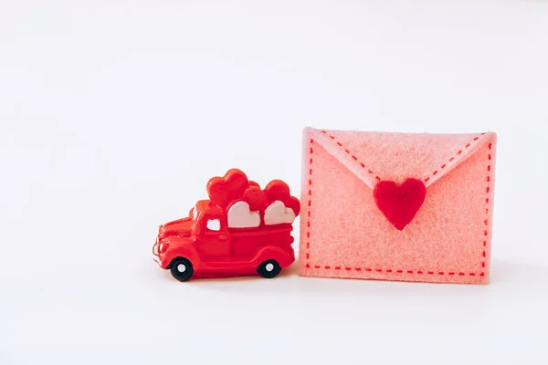 Μινιατούρα Κόκκινο Αυτοκίνητο Καρδιές Και Τσόχα Φάκελο Λευκό Φόντο Ημέρα — Φωτογραφία Αρχείου
