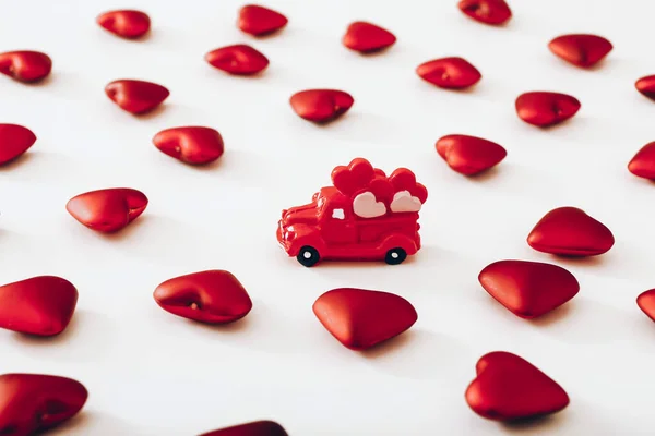 Minyatür Kırmızı Araba Beyaz Arka Planda Bir Sürü Kalp Sevgililer — Stok fotoğraf