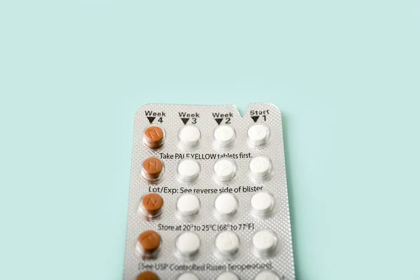 Female oral contraceptive pills blister on color background. Women contraceptive hormonal birth control pills.