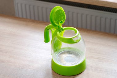 Masadaki elektrikli çaydanlığın dibindeki sert sudan ölçeklendir. 