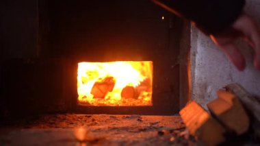 Erkekler odunları demir bir sobaya koyarlar. Ukrayna Karartması. 