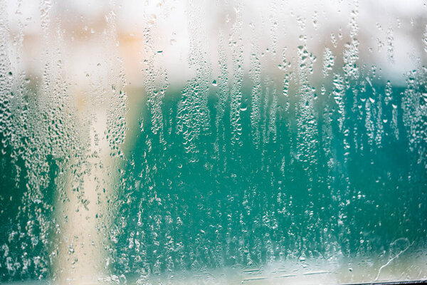 Капельки конденсации на пластиковом оконном стекле от изменения температуры. 