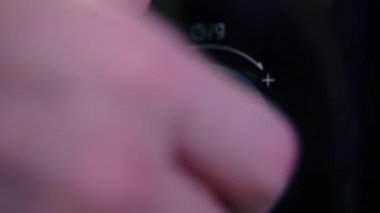 Mans hand twists the microwave timer button, counting down. Close-up. 