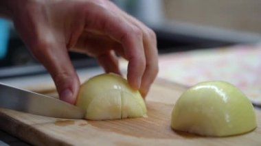 Mens hands cut a white bow with a knife on a cutting board, close-up. 