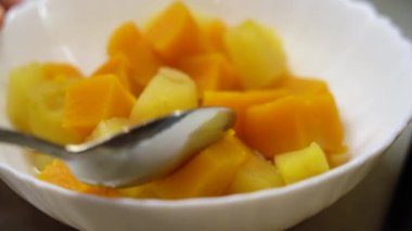Orange pumpkin is cut into pumpkin, showing readiness in white plate. 