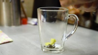 Zencefil parçalara ayrılır ve yeşil çay yapmak için bir bardağa düşer.. 