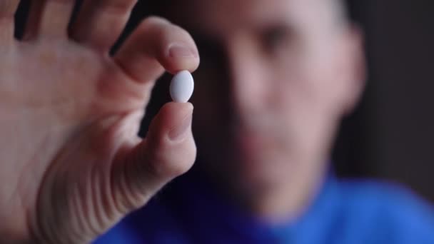 Mans Hand Holds White Pill Background Blurred Face — Vídeo de Stock