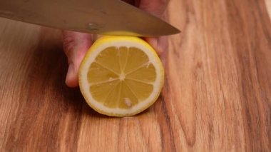 Erkekler sarı bir limon tutar ve limonu dilimlere ayırır.. 