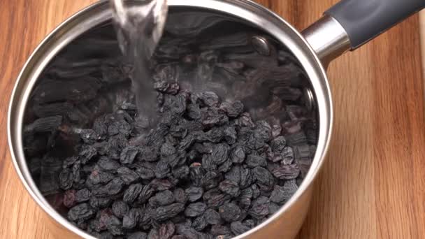 金属锅里的黑葡萄干被倒入水中 — 图库视频影像