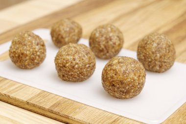 Enerji topları tahta bir masanın üzerinde duran beyaz bir kesme tahtasındaki şekerler. 