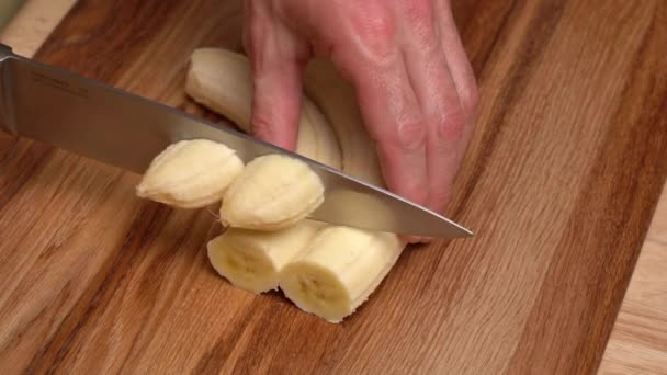 Mens Ręce Nożem Wyciąć Dojrzały Banan Drewnianej Desce Krojenia — Wideo stockowe