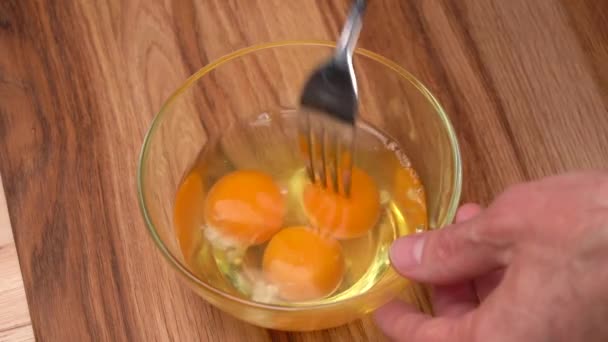 Мужские Руки Мешают Металлической Вилке Сырые Яйца Стеклянной Чаше — стоковое видео