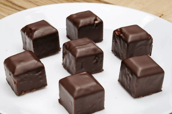 Masadaki Beyaz Tabakta Kare Şeklinde Çikolatalar — Stok fotoğraf