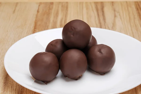 Schokoladenkugeln Einer Pyramide Auf Einem Weißen Teller Auf Dem Tisch — Stockfoto
