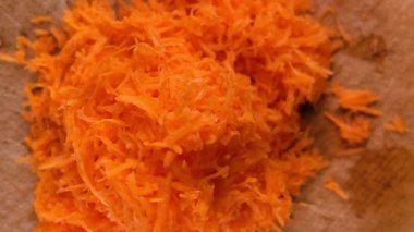 Taze rendelenmiş havucun detaylı bir görüntüsü, salatalara, tariflere ve sağlıklı yemeklere besleyici bir dokunuş eklemek için mükemmel. Mutfak ve sağlık odaklı video içeriği için ideal.