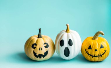 Güzel balkabakları mavi bir arka planda kitap yığınının üzerinde oturuyor. Yaratıcı cadılar bayramı kavramı geri çekilmesi. Sonbahar okuma kavramı. Okumak için sonbahar kitapları. Çocuklar Cadılar Bayramı Balkabağı Gemisi.