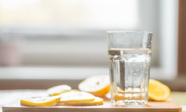 Limon dilimleri ve bir bardak su yakın. Sağlıklı yiyecek veya içecek konsepti.