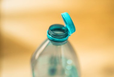 Plastik kapak plastik bir şişeye bağlı. Atık geri dönüşümünü kolaylaştırmak için şişe kapağına takılı şişe tasarımı.