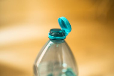 Plastik kapak plastik bir şişeye bağlı. Atık geri dönüşümünü kolaylaştırmak için şişe kapağına takılı şişe tasarımı.