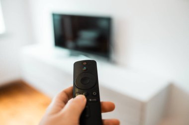 Hand with remote control. Streaming services and watching TV concept.	