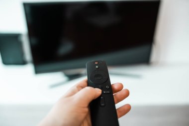 Hand with remote control. Streaming services and watching TV concept.	