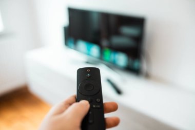 Hand with remote control. Streaming services and watching TV concept.	