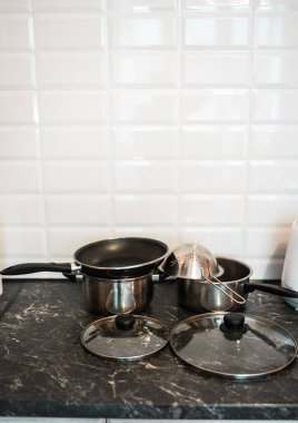 Çömlek ve diğer mutfak gereçleri mutfağın üstünde. Temiz mutfak konsepti.