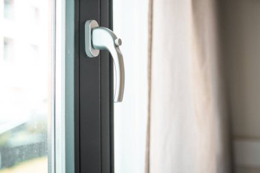 Woman opens a glass door or window handle with security lock button.	