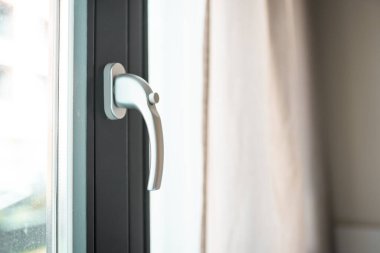 Woman opens a glass door or window handle with security lock button.	
