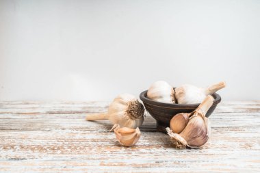 Taklit alanı olan ahşap bir masada sarımsak ampulleri. Beslenme kavramı.