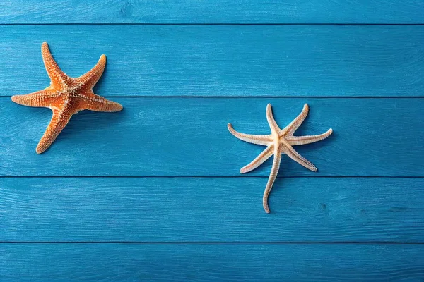 two starfishs are on a blue wood planks background