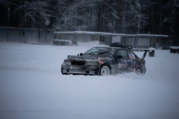 ラトビア リガ2012年12月12日2022年12月12日雪に覆われた駐車場を雪上車で走る車 — ストック写真