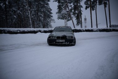 12-12-2022 Riga, Letonya Karlı bir yolda bir araba park halinde.. .