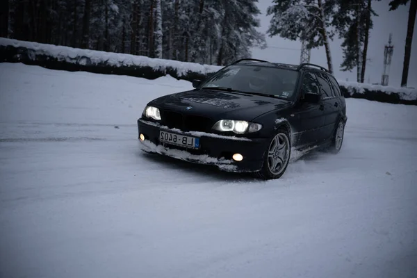 周りに誰もいない寒い日に ラトビアのリガ12 2022車が森の中の雪を通って運転しています — ストック写真