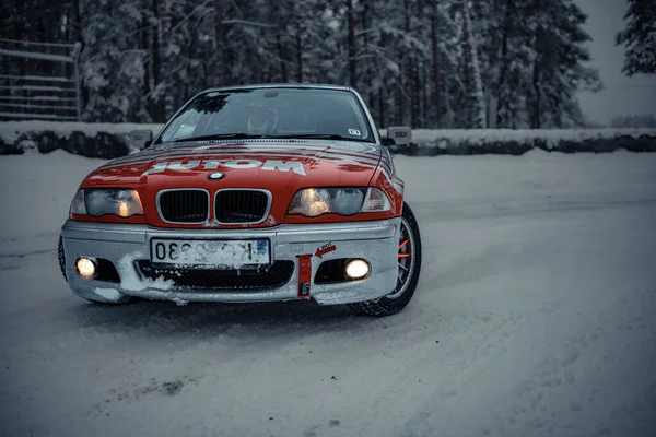 2022 Ryga Łotwa Czerwony Samochód Zaparkowany Śniegu Pobliżu Drzew Pokrytego — Zdjęcie stockowe