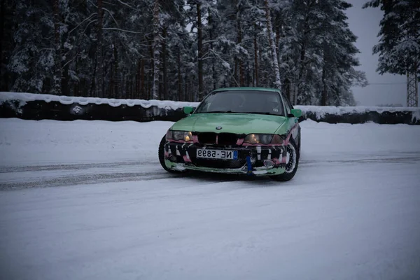 2022 Ryga Łotwa Zielony Samochód Jadący Pokrytej Śniegiem Drodze Obok — Zdjęcie stockowe