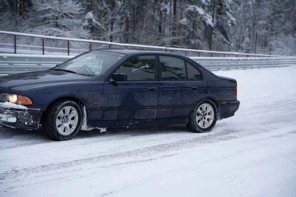 ラトビア リガ2012年12月12日2022年12月12日雪に覆われた道に青い車が停まっている — ストック写真