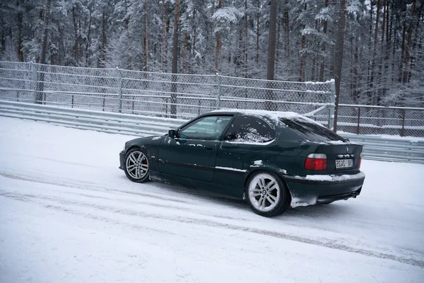 ラトビア リガ2012年12月12日2022年12月12日地面に雪が積もる中 柵や木の近くの雪道に車が停まりました — ストック写真