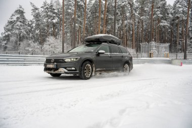 12-12-2022 Riga, Letonya üstü karla kaplı bir ormandan geçen bir araba çatısında bir çatı ve karla kaplı bir zemin. .
