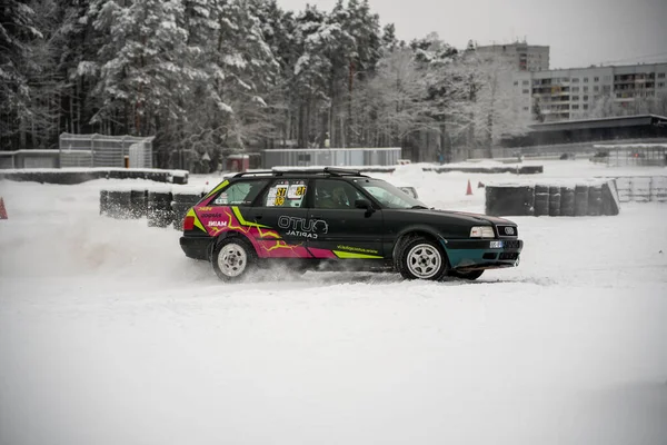 2022 라트비아의 자동차가 눈덮인 들판을 운전하고 나무들이 표지가 새겨져 — 스톡 사진