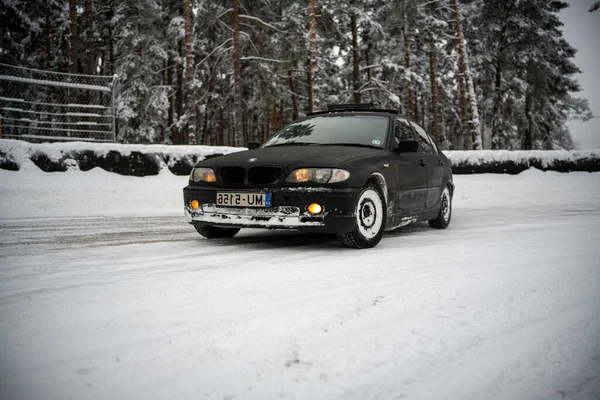 2012年12月12日 2022年リガ ラトビア木々の横に雪に覆われた道路を運転する黒い車とその側面に雪のフェンス — ストック写真