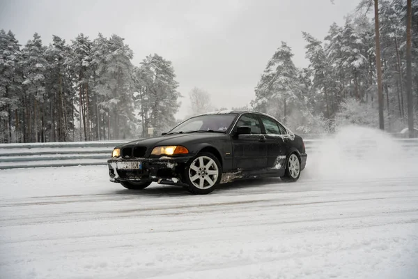 2022 Ryga Łotwa Czarny Samochód Jadący Śnieżną Drogą Obok Lasu — Zdjęcie stockowe