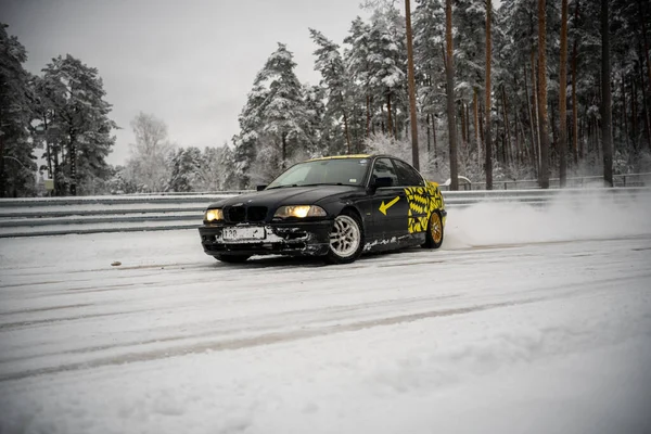 2022 Ryga Łotwa Czarny Samochód Jadący Pokrytą Śniegiem Drogą Obok — Zdjęcie stockowe