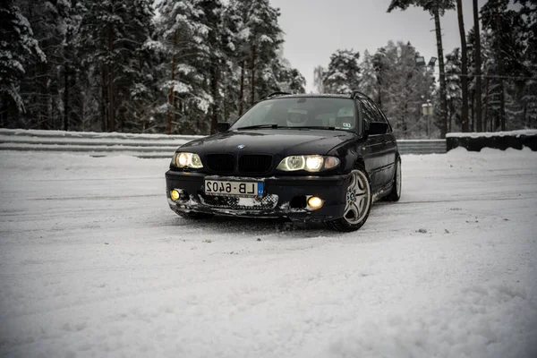 2022 Ryga Łotwa Czarny Samochód Zaparkowany Śniegu Pobliżu Drzew Płot — Zdjęcie stockowe