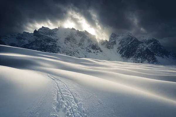 a snow covered mountain with a trail in the snow and a sun peeking through the clouds above it and a dark sky. .