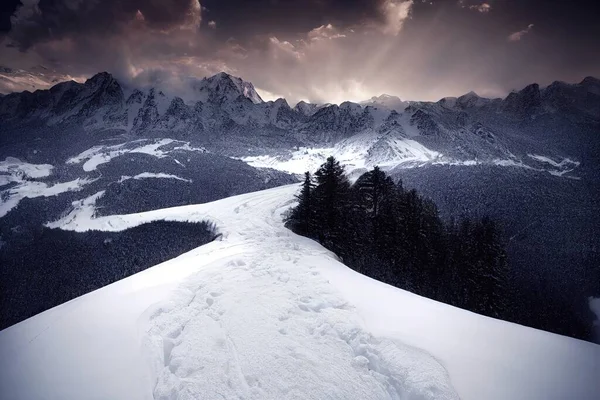 a snow covered mountain with a trail going through it and a cloudy sky above it with sunbeams. .