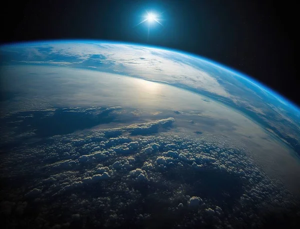 a view of the earth from space with a bright sun in the background.